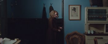 Movie still from “The Zookeeper's Wife” (2017), directed by Niki Caro – A woman standing in front of a blue wall; Medium shot, Over the shoulder angle