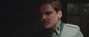 Movie still from “The Zookeeper's Wife” (2017), directed by Niki Caro – A person wearing a uniform; Close Up shot, Low angle