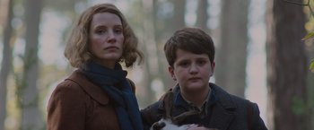 Movie still from “The Zookeeper's Wife” (2017), directed by Niki Caro – A woman standing next to a young boy holding a cat; Close Up shot, Low angle