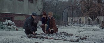 Movie still from “The Zookeeper's Wife” (2017), directed by Niki Caro – A group of people sitting on the ground in the middle of a field; Medium shot, High angle