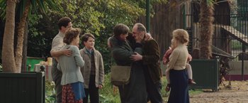 Movie still from “The Zookeeper's Wife” (2017), directed by Niki Caro – A group of people standing around each other hugging each other; Medium shot, Over the shoulder angle