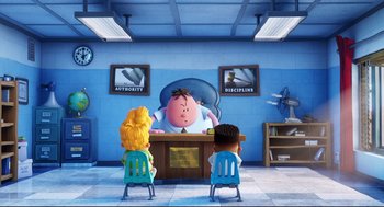 Movie still from “Captain Underpants: The First Epic Movie” (2017), directed by David Soren – Two children sitting at a desk in front of a pig; Wide shot, High angle
