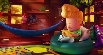 Movie still from “Captain Underpants: The First Epic Movie” (2017), directed by David Soren – A cartoon character sitting on top of a green chair; Wide shot, High angle