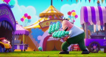 Movie still from “Captain Underpants: The First Epic Movie” (2017), directed by David Soren – A man holding a tray full of food in front of an amusement park; Wide shot, Low angle