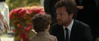 Movie still from “This Is Where I Leave You” (2014), directed by Shawn Levy – A man in a suit talking to a boy in a suit; Close Up shot, Over the shoulder angle