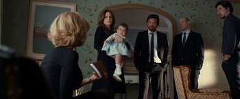 Movie still from “This Is Where I Leave You” (2014), directed by Shawn Levy – A woman holding a baby in front of two men in a room; Medium shot, Over the shoulder angle
