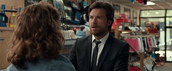 Movie still from “This Is Where I Leave You” (2014), directed by Shawn Levy – A man in a suit and tie talking to a woman in a store; Close Up shot, Over the shoulder angle