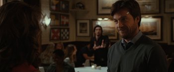 Movie still from “This Is Where I Leave You” (2014), directed by Shawn Levy – A group of people sitting at a table in a room; Medium shot, Over the shoulder angle