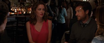 Movie still from “This Is Where I Leave You” (2014), directed by Shawn Levy – A woman in a red dress sitting next to a group of people; Close Up shot, Over the shoulder angle
