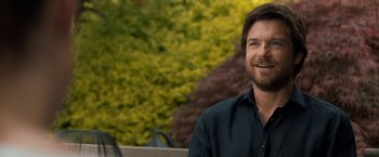 Movie still from “This Is Where I Leave You” (2014), directed by Shawn Levy – A man sitting on top of a bench next to trees; Close Up shot, Over the shoulder angle