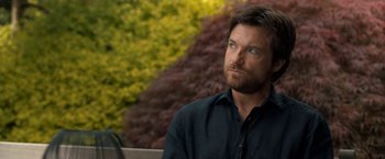 Movie still from “This Is Where I Leave You” (2014), directed by Shawn Levy – A person sitting on a bench near a tree; Close Up shot, Over the shoulder angle