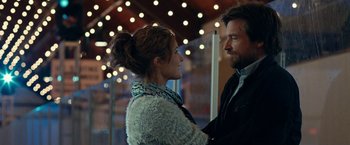 Movie still from “This Is Where I Leave You” (2014), directed by Shawn Levy – A man and a woman standing next to each other in front of lights; Medium shot, Over the shoulder angle