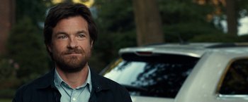Movie still from “This Is Where I Leave You” (2014), directed by Shawn Levy – A person wearing a jacket near a car; Close Up shot, Over the shoulder angle