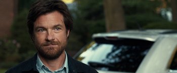 Movie still from “This Is Where I Leave You” (2014), directed by Shawn Levy – A person wearing a jacket near a car; Close Up shot, Over the shoulder angle