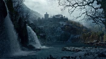 Movie still from “Game of Thrones” (2011), created by D.B. Weiss – A waterfall in the middle of a lake with a castle in the background; Extreme Wide shot, High angle