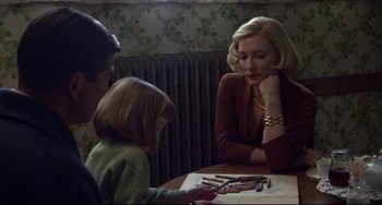 Movie still from “Carol” (2015), directed by Todd Haynes – A woman sitting at a table with two children; Medium shot, Over the shoulder angle