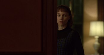 Movie still from “Carol” (2015), directed by Todd Haynes – A woman standing next to a door looking at the camera; Medium shot, Over the shoulder angle