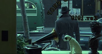 Movie still from “Carol” (2015), directed by Todd Haynes – A dog sitting next to a man in a hat; Wide shot, High angle