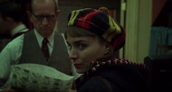 Movie still from “Carol” (2015), directed by Todd Haynes – A woman wearing a colorful hat in front of an older man; Close Up shot, Over the shoulder angle