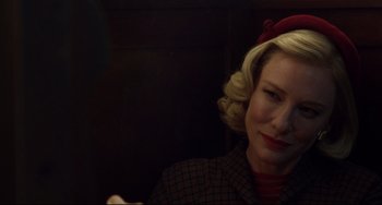 Movie still from “Carol” (2015), directed by Todd Haynes – A woman with blonde curly hair wearing a red hat; Close Up shot, Over the shoulder angle