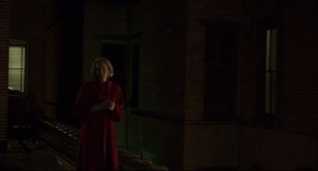 Movie still from “Carol” (2015), directed by Todd Haynes – A woman in a red coat standing in the dark; Wide shot, Over the shoulder angle