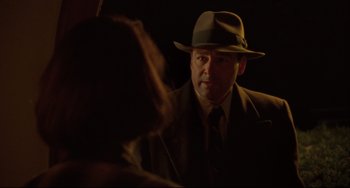 Movie still from “Carol” (2015), directed by Todd Haynes – A man wearing a suit and a hat is talking to a woman; Close Up shot, Over the shoulder angle
