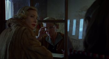 Movie still from “Carol” (2015), directed by Todd Haynes – A woman looking in a mirror while another looks in the mirror; Close Up shot, Over the shoulder angle