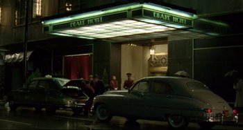 Movie still from “Carol” (2015), directed by Todd Haynes – A group of people sitting in front of a building; Extreme Wide shot, Low angle
