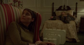 Movie still from “Carol” (2015), directed by Todd Haynes – A woman sitting in a chair in front of a bed; Medium shot, High angle