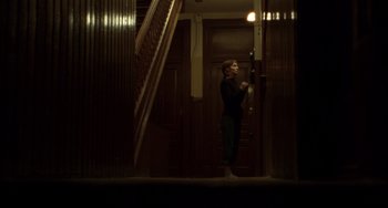 Movie still from “Carol” (2015), directed by Todd Haynes – A woman standing in a doorway looking out of a door way; Wide shot, Low angle