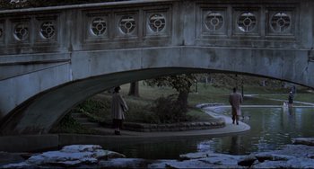 Movie still from “Carol” (2015), directed by Todd Haynes – Two people standing under a bridge near a body of water; Extreme Wide shot, High angle