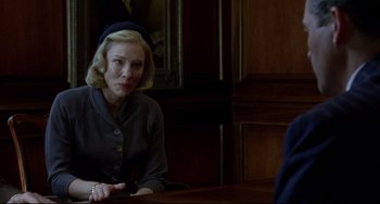 Movie still from “Carol” (2015), directed by Todd Haynes – A woman sitting at a table in front of a man; Medium shot, Over the shoulder angle