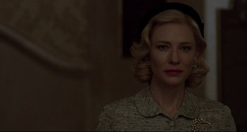 Movie still from “Carol” (2015), directed by Todd Haynes – A woman with a black hat is standing in a room; Close Up shot, Low angle