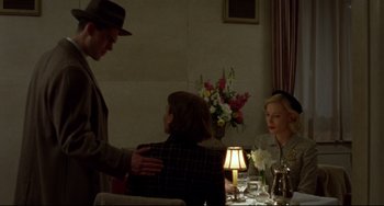 Movie still from “Carol” (2015), directed by Todd Haynes – A man and a woman standing in front of a woman; Medium shot, Over the shoulder angle