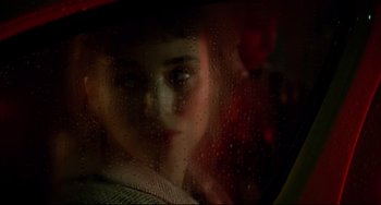 Movie still from “Carol” (2015), directed by Todd Haynes – A woman looking through a window with rain drops on it; Close Up shot, Over the shoulder angle