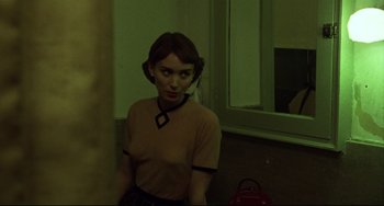 Movie still from “Carol” (2015), directed by Todd Haynes – A woman is standing in front of a bathroom mirror; Medium shot, Over the shoulder angle