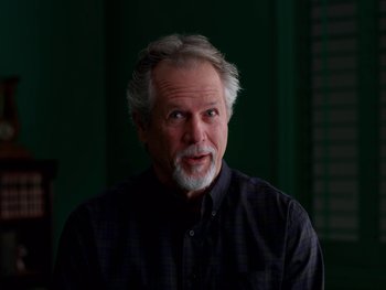 Movie still from “Casting JonBenet” (2017), directed by Kitty Green – An older man in a black shirt is looking at the camera; Close Up shot, Low angle
