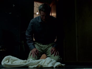 Movie still from “Casting JonBenet” (2017), directed by Kitty Green – A man kneeling down on the floor in front of a blanket; Medium shot, Low angle