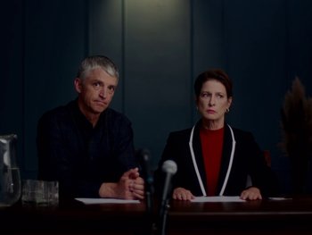 Movie still from “Casting JonBenet” (2017), directed by Kitty Green – A man and a woman sitting in front of microphones; Medium shot, Over the shoulder angle