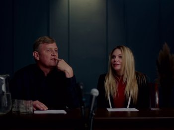 Movie still from “Casting JonBenet” (2017), directed by Kitty Green – A man and a woman sitting at a table; Medium shot, Over the shoulder angle