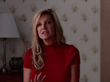 Movie still from “Casting JonBenet” (2017), directed by Kitty Green – A woman in a red shirt standing in front of a wall; Close Up shot, Low angle