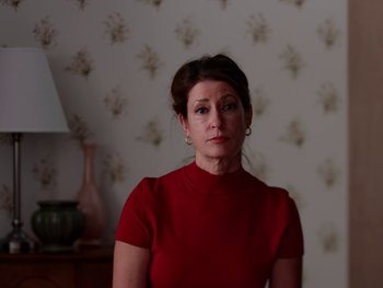 Movie still from “Casting JonBenet” (2017), directed by Kitty Green – A woman in a red shirt is looking at the camera; Close Up shot, Low angle