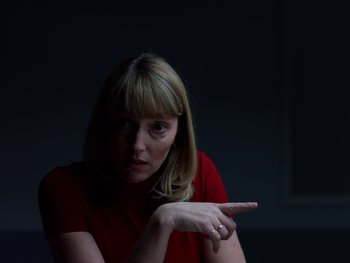 Movie still from “Casting JonBenet” (2017), directed by Kitty Green – A woman in a red shirt is pointing to the side; Close Up shot, Over the shoulder angle