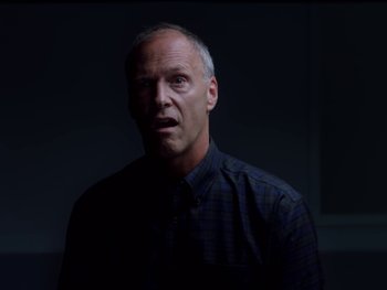 Movie still from “Casting JonBenet” (2017), directed by Kitty Green – A man in a black shirt is looking at the camera; Close Up shot, Low angle