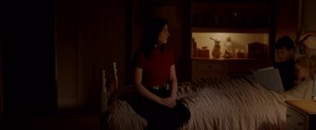 Movie still from “Casting JonBenet” (2017), directed by Kitty Green – A woman sitting on top of a bed in the dark; Medium shot, Over the shoulder angle