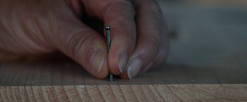 Movie still from “Umma” (2022), directed by Iris K. Shim – A person is holding a piece of wood with a nail in it; Extreme Close Up shot, High angle