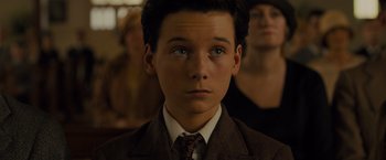 Movie still from “Unbroken” (2014), directed by Angelina Jolie – A young man in a suit and tie; Close Up shot, High angle