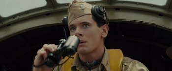 Movie still from “Unbroken” (2014), directed by Angelina Jolie – A man in a military uniform holding a pair of binoculars; Close Up shot, Low angle