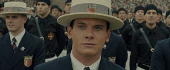 Movie still from “Unbroken” (2014), directed by Angelina Jolie – A person wearing a suit and a hat; Close Up shot, High angle
