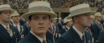 Movie still from “Unbroken” (2014), directed by Angelina Jolie – A group of men in suits and straw hats in front of a crowd; Close Up shot, High angle